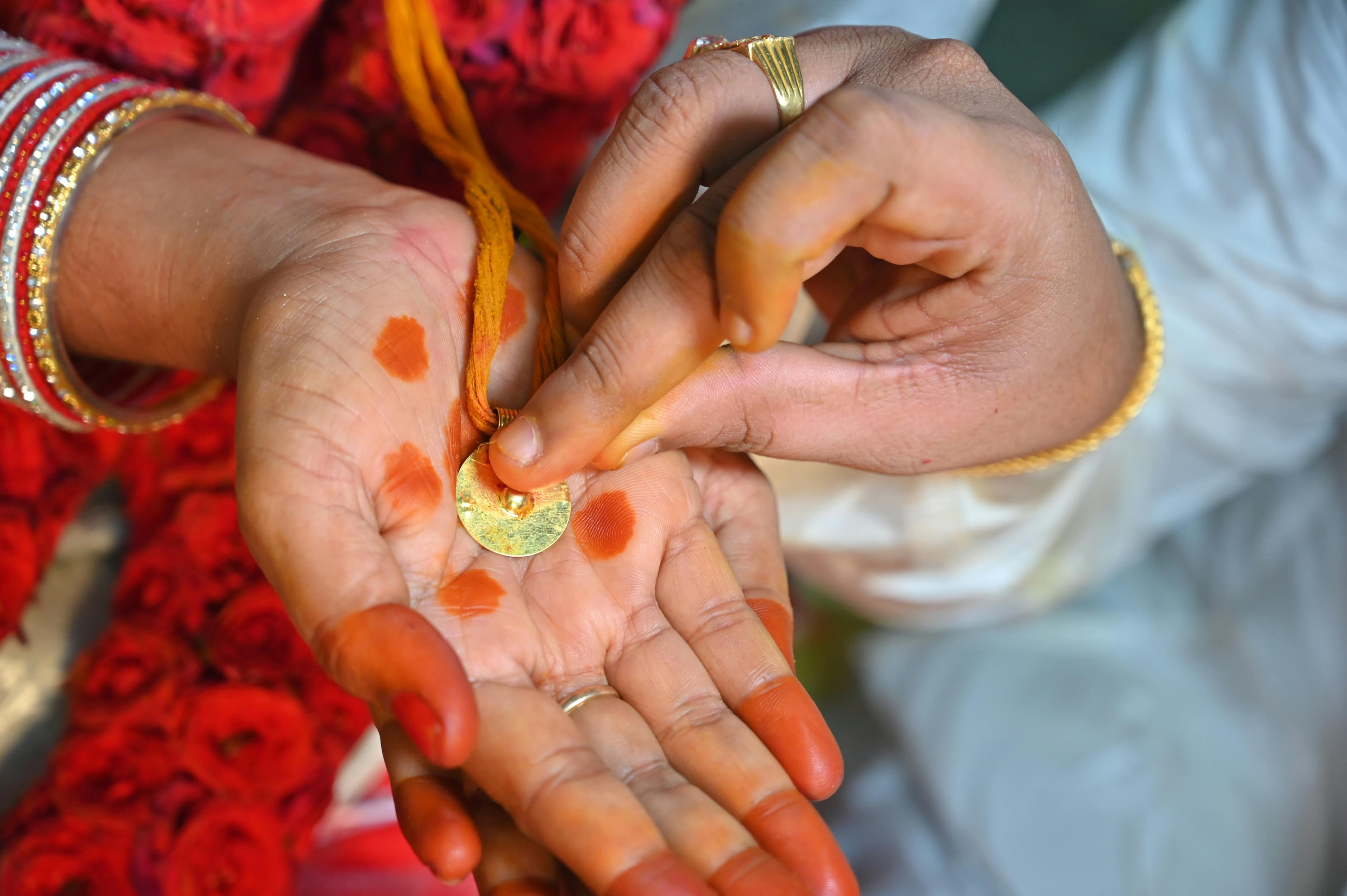 Bride and groom holding a brass kalasha — a traditional Telugu wedding ritual