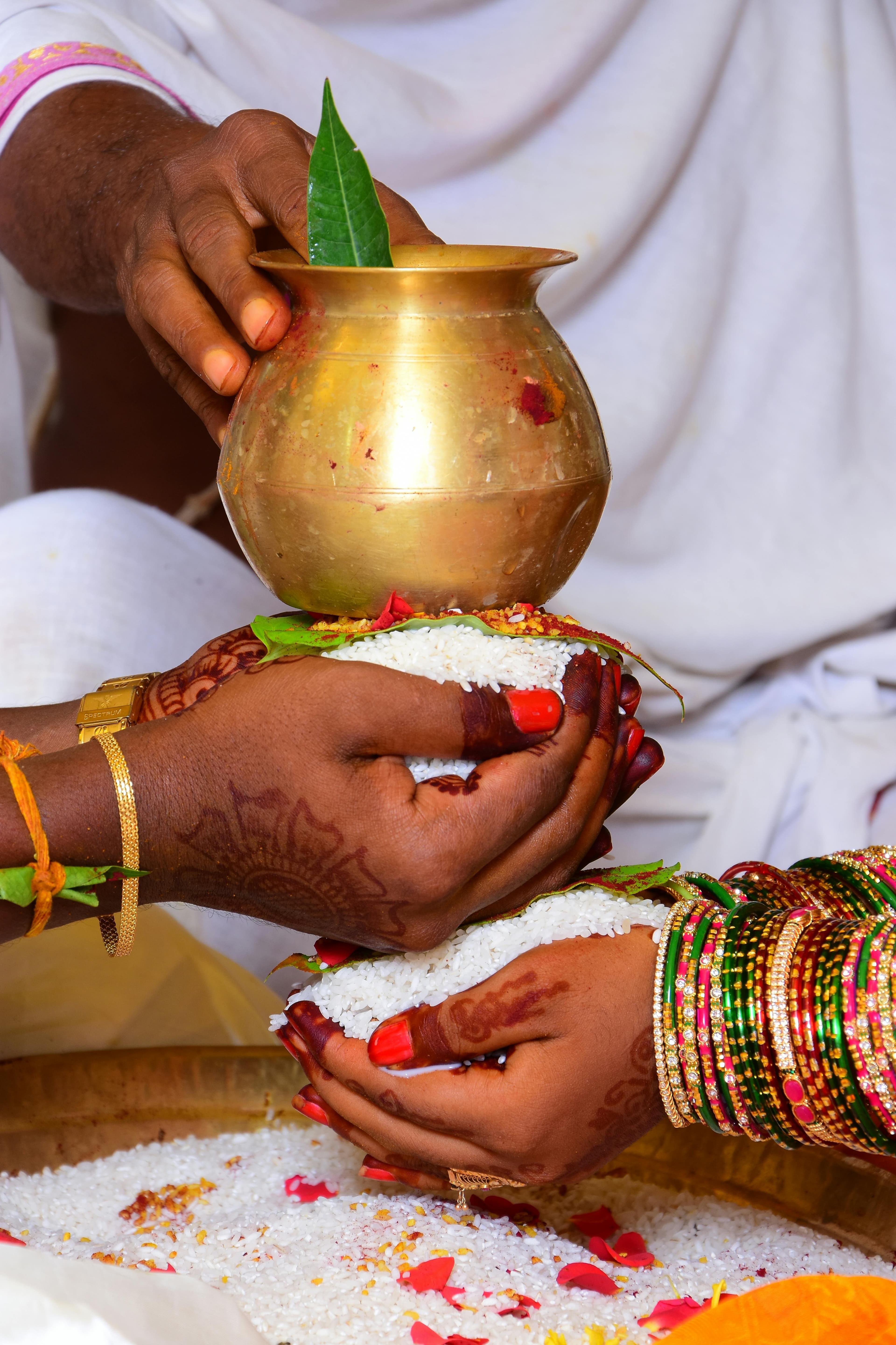 Bride and groom holding a brass kalasha — a traditional Telugu wedding ritual