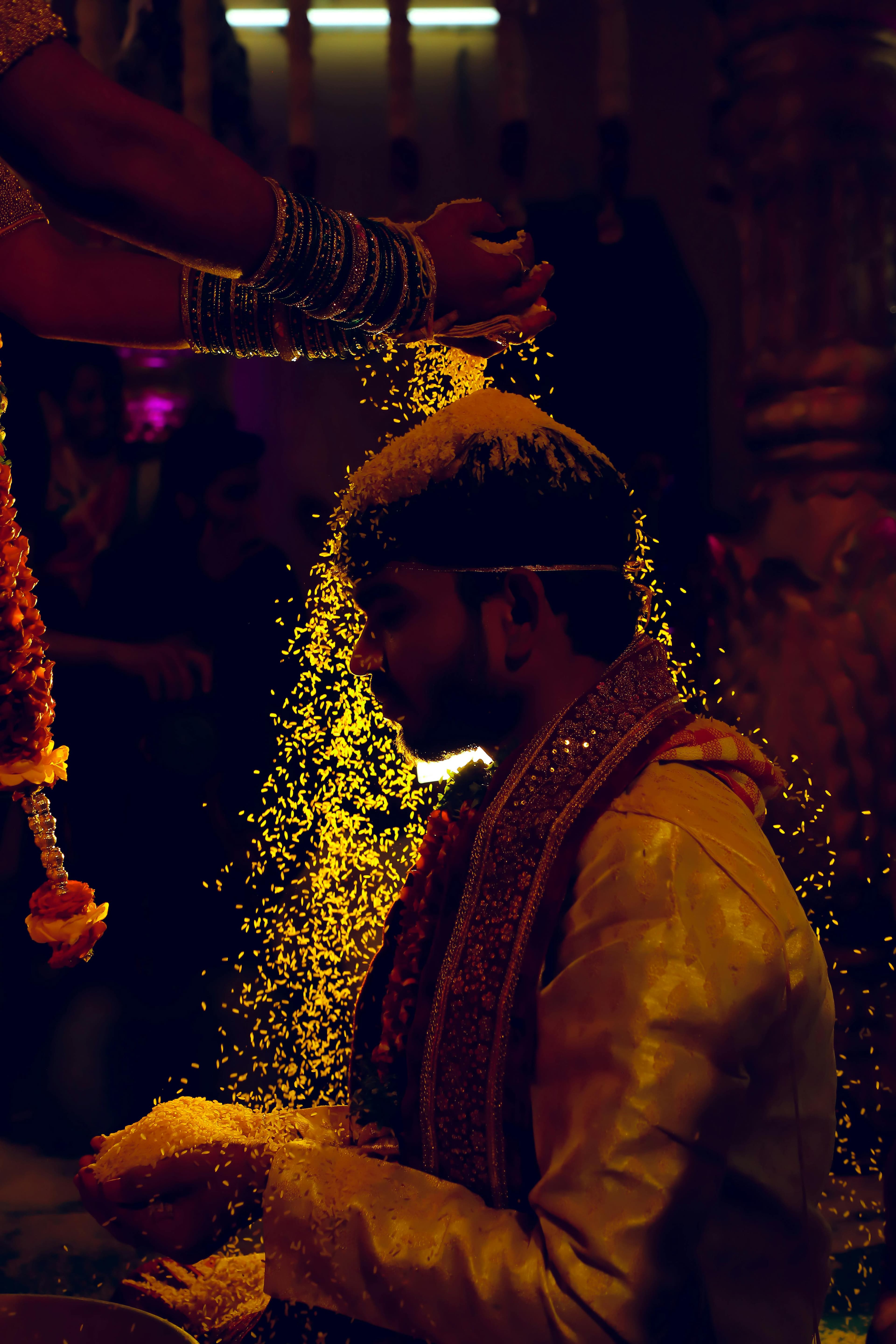 Groom during the talambralu ritual — yellow rice being showered as a blessing